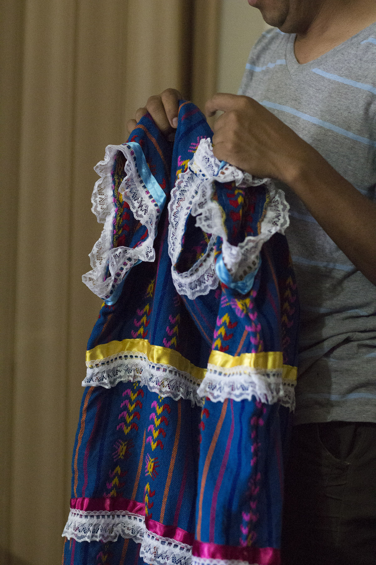  Benito Bravo holds up a costume made by indigenous women in Mexico, noting the stitching and careful attention to detail in the handiwork. &nbsp;Gabrielle Narcisse and Deleelah Saleh for Picture Justice.&nbsp;August 22, 2017. 