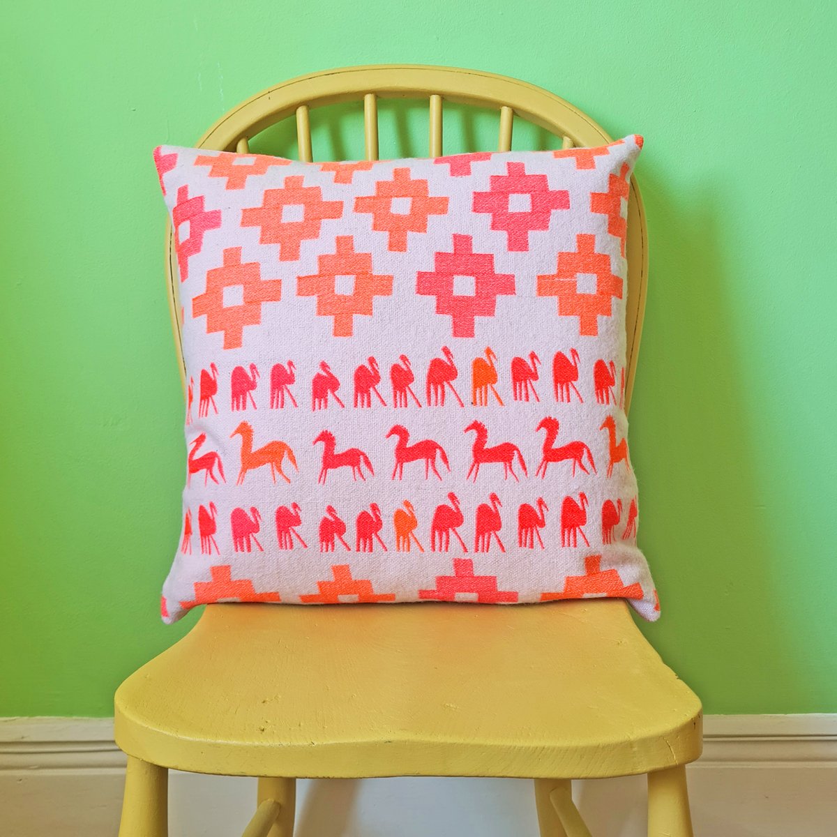 pink wool square cushion with pink and orange embroidered animals