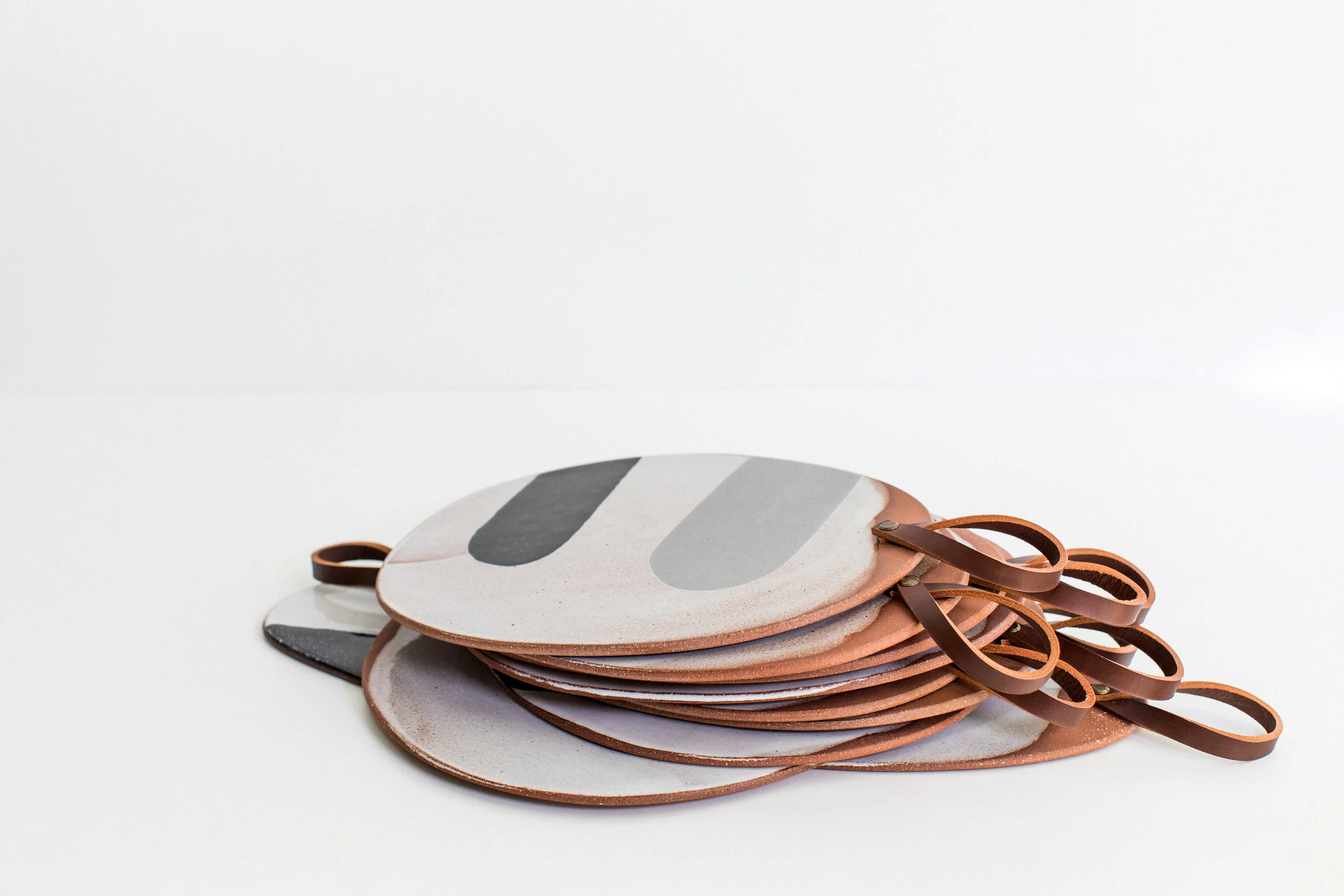 Hand rolled terracotta platters with naturally dyed British leather handles