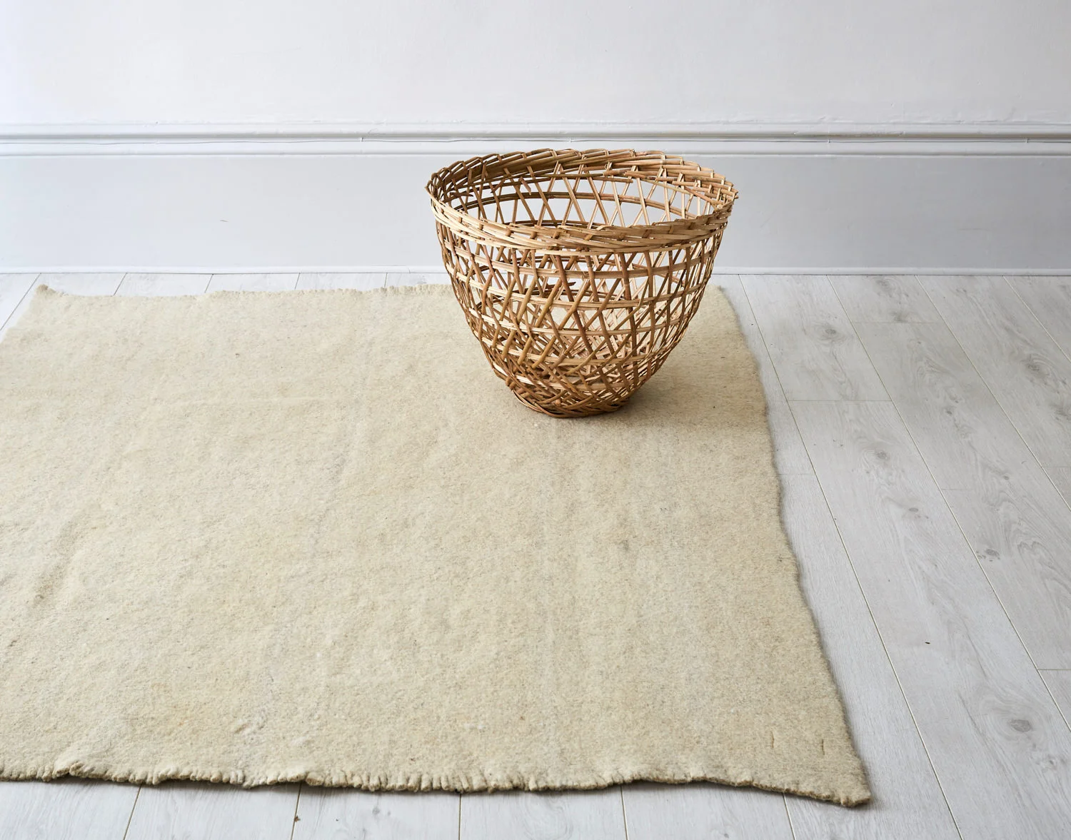 Cream wool rug on wooden floor