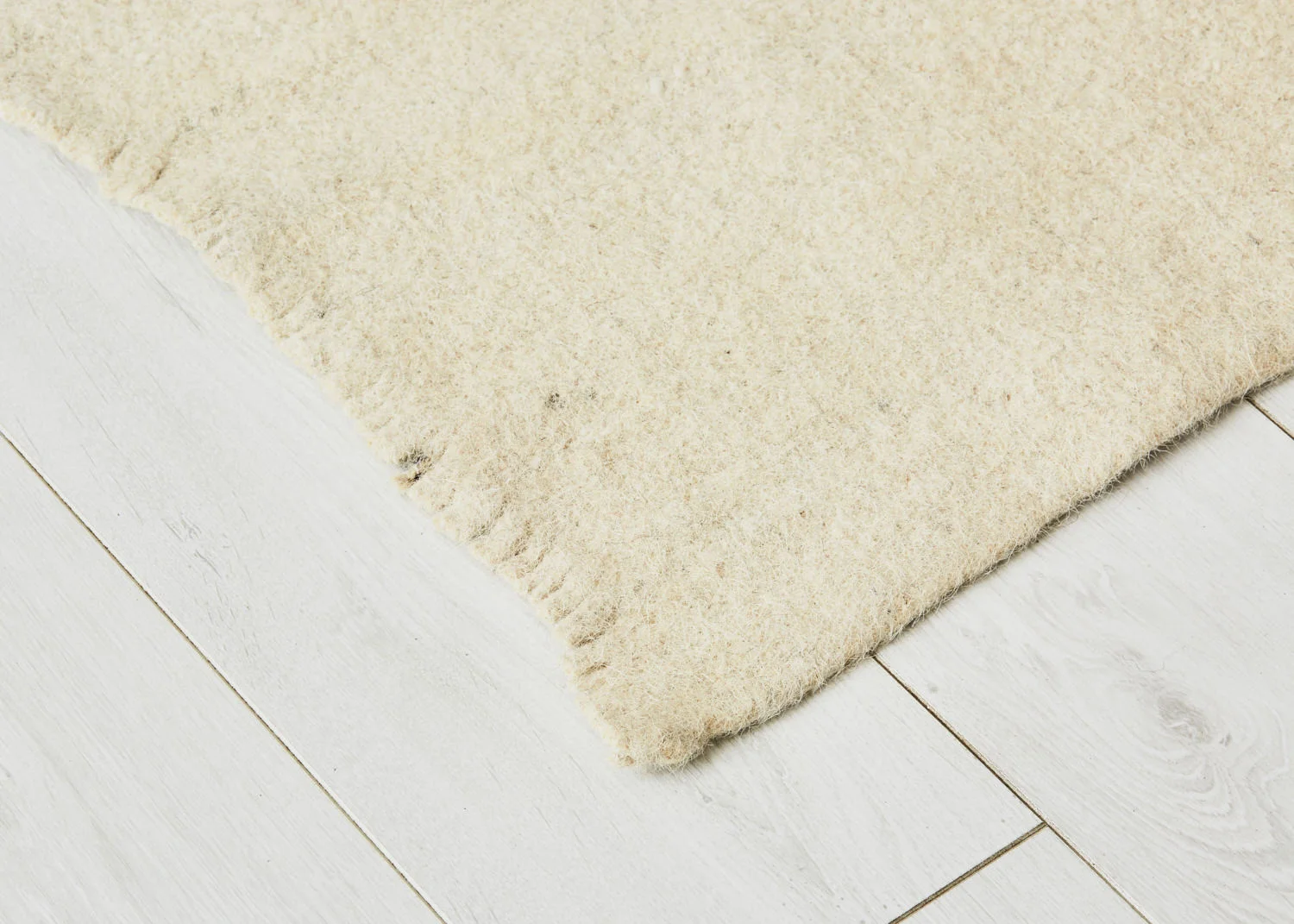 Cream wool rug with fringed edges