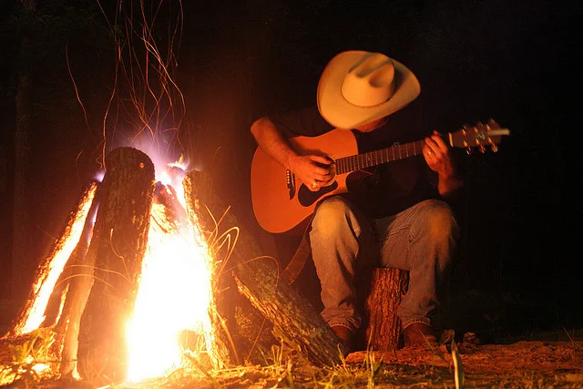 texan cowboy playing guitar in front of campfire.jpg