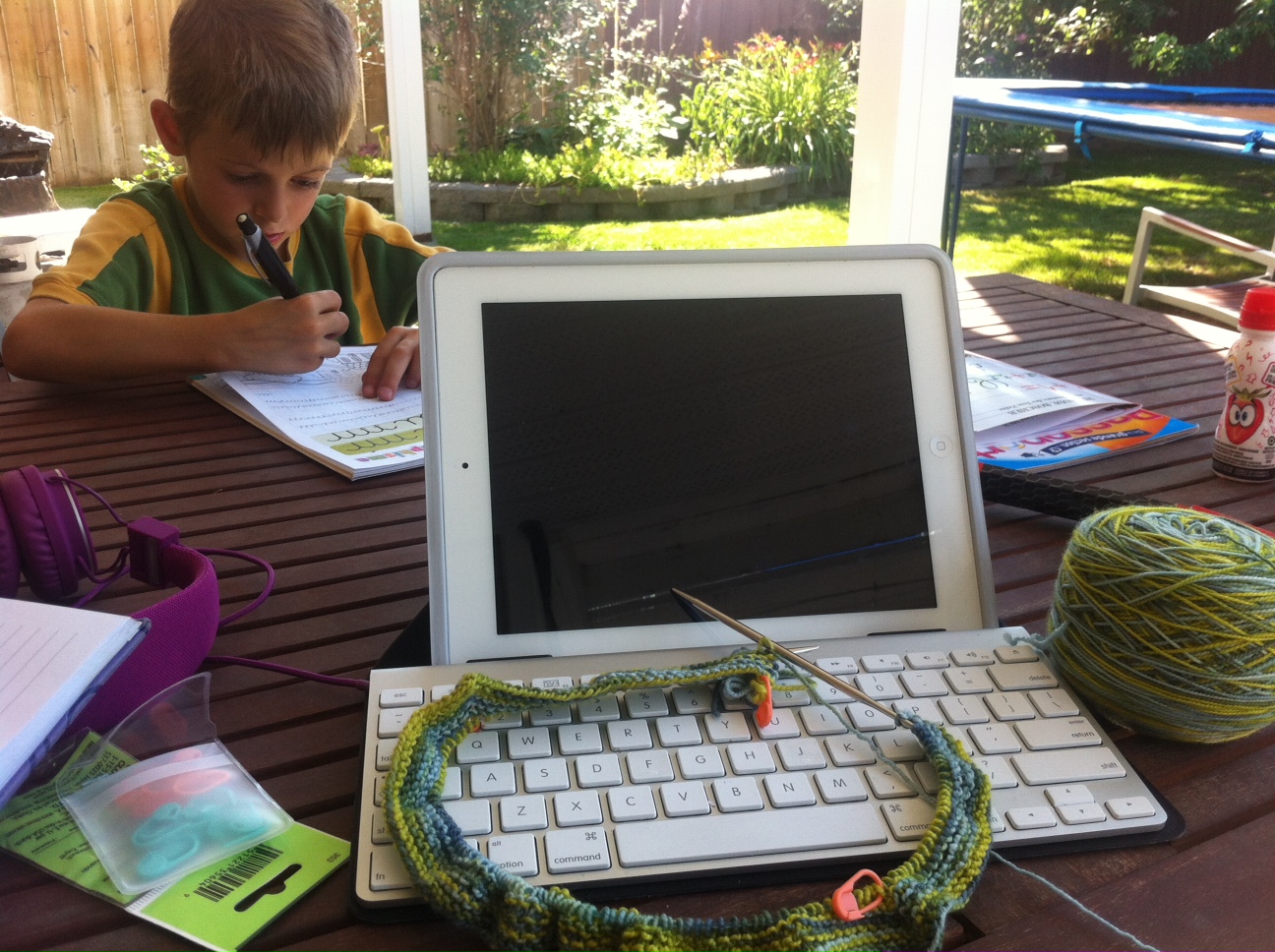 Harrison diligently doing his graphisme while mummy knits, er, looks on.