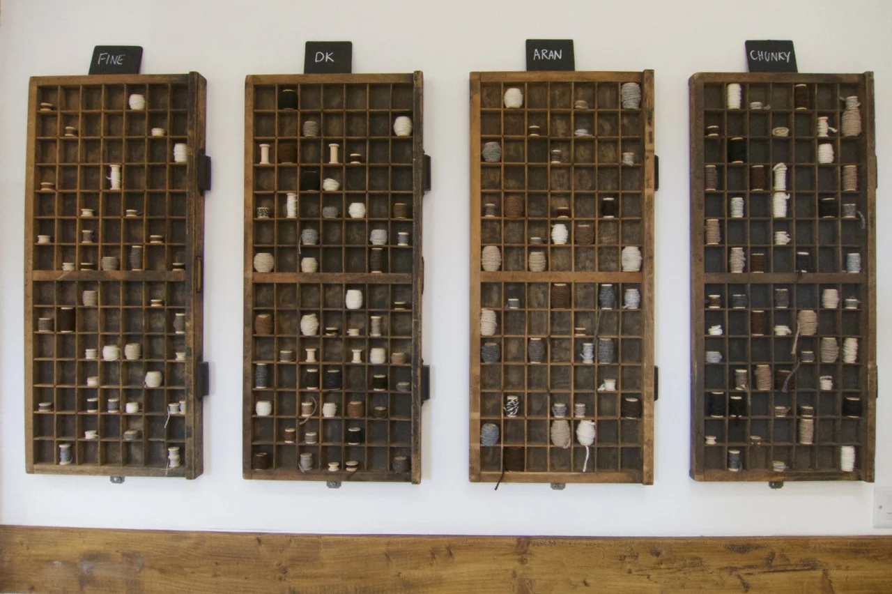 A clever use for old printing trays - art created from scraps of yarn wrapped on tiny sewing bobbins