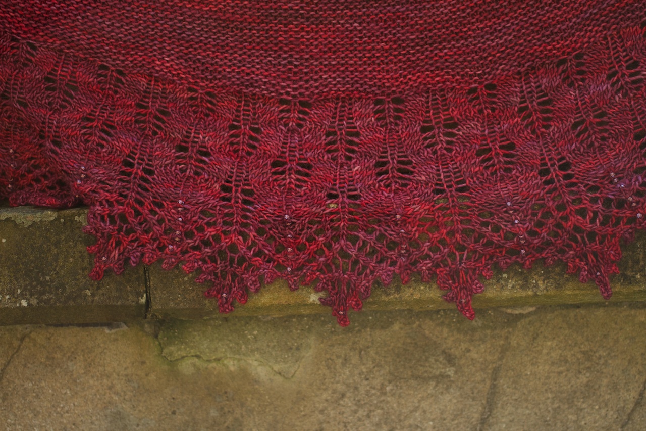I love how the iridescent pale purple beads shimmer and pick up the reds and purples in the yarn.