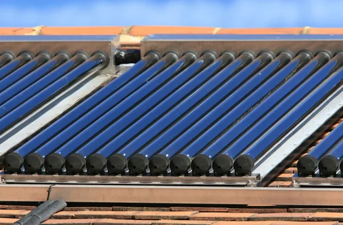 Solar glass tube hot water panel array mounted on a tiled roof