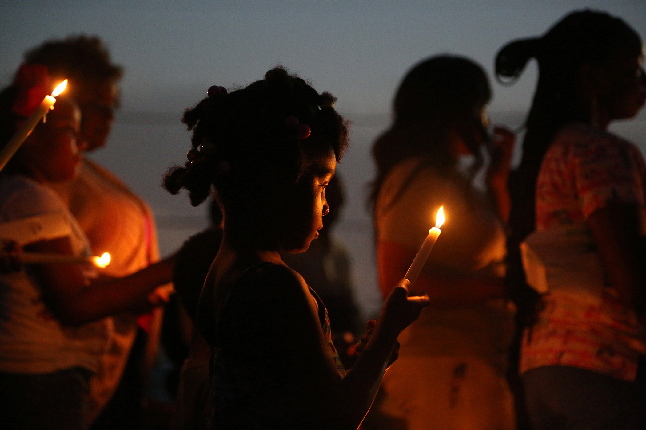   Friends and family of Trammell Marshall and Johnell Ovide gather Monday, June 22, 2015, to honor and mourn the men killed in Sunday night's triple shooting in Harvey, Louisiana.  