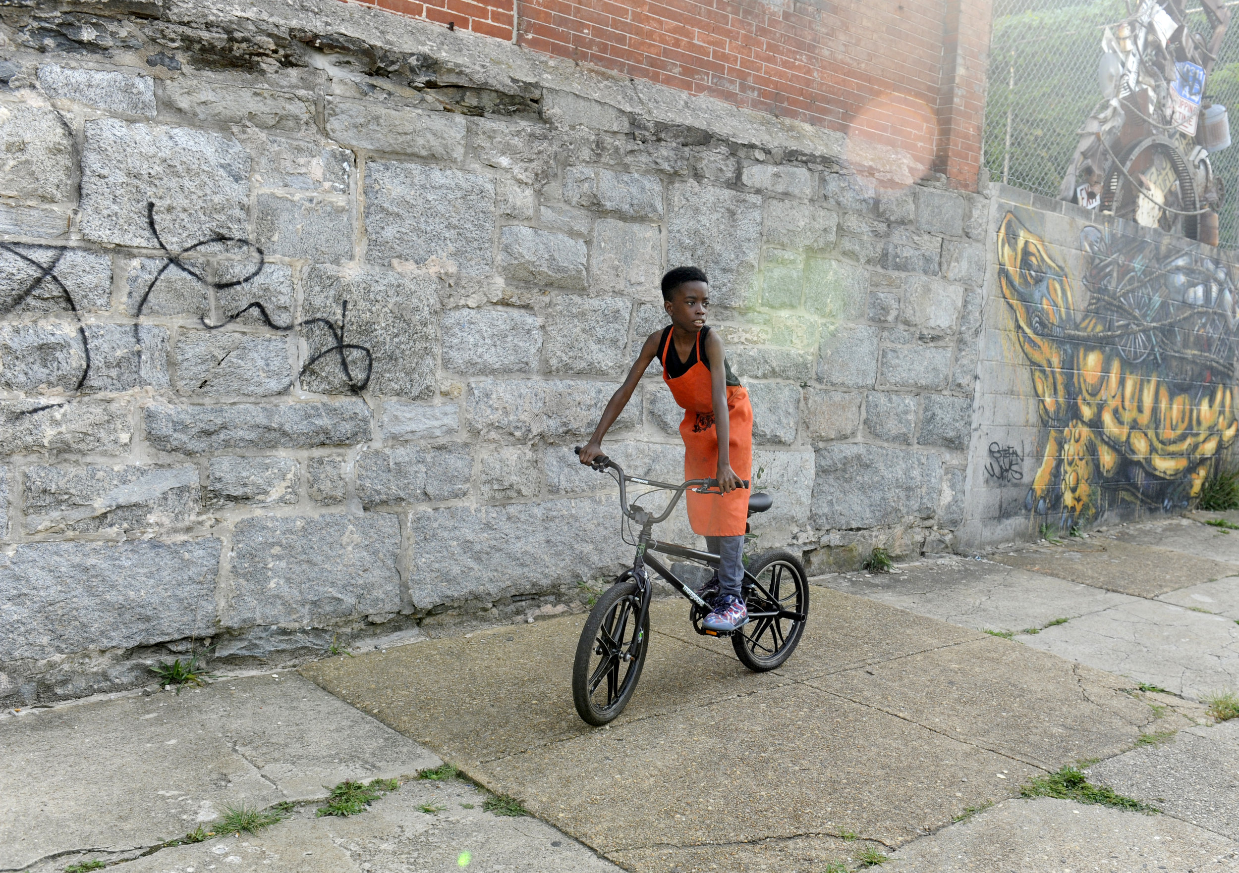  Tisean Muhummad, 12, rides outside BYKE headquarters on E Oliver Street in Baltimore, Maryland on Thursday, September 8, 2016. The Baltimore Youth Kinetic Energy Collective (BYKE) is a youth empowerment after-school program. 