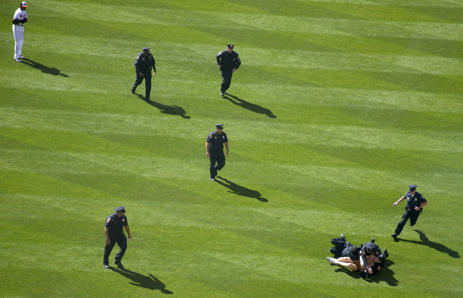  Mark Harvey of Severn, Maryland, is pinned down by police after running across the Camden Yards field during the Baltimore Orioles Opening Day on April 6, 2012. &nbsp; 