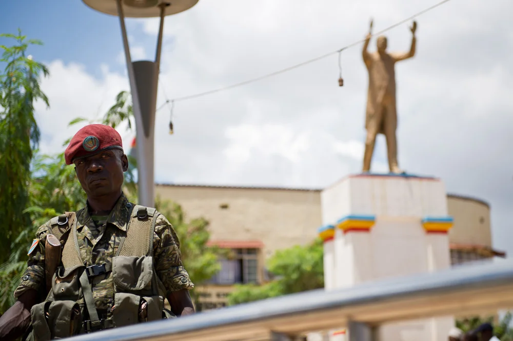 A soldier stands below the statue of Moise Tshombe