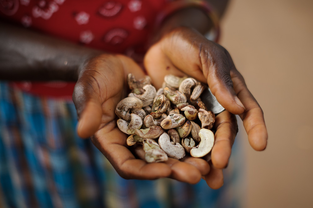  ​A lady holds $1 (USD) worth of cashew nuts, for sale in the streets of Bissau 