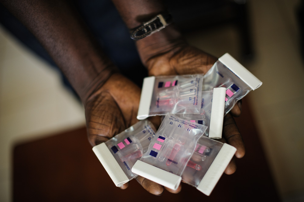  ​A Bissau-Guinean drug enforcement officer holds bags of cocaine testing kits. 