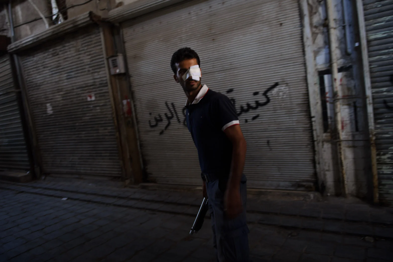 An injured Syrian rebel walks through the souq in Aleppo's UNESCO-listed Old City