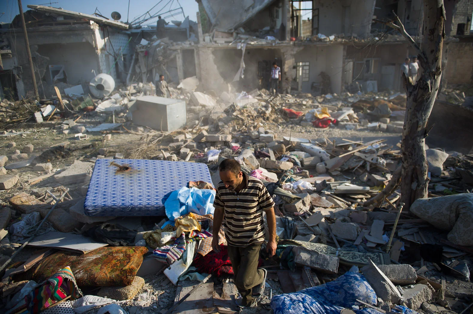 A man walks through the rubble of his destroyed house following an aerial bombing raid in Azaz, Syria