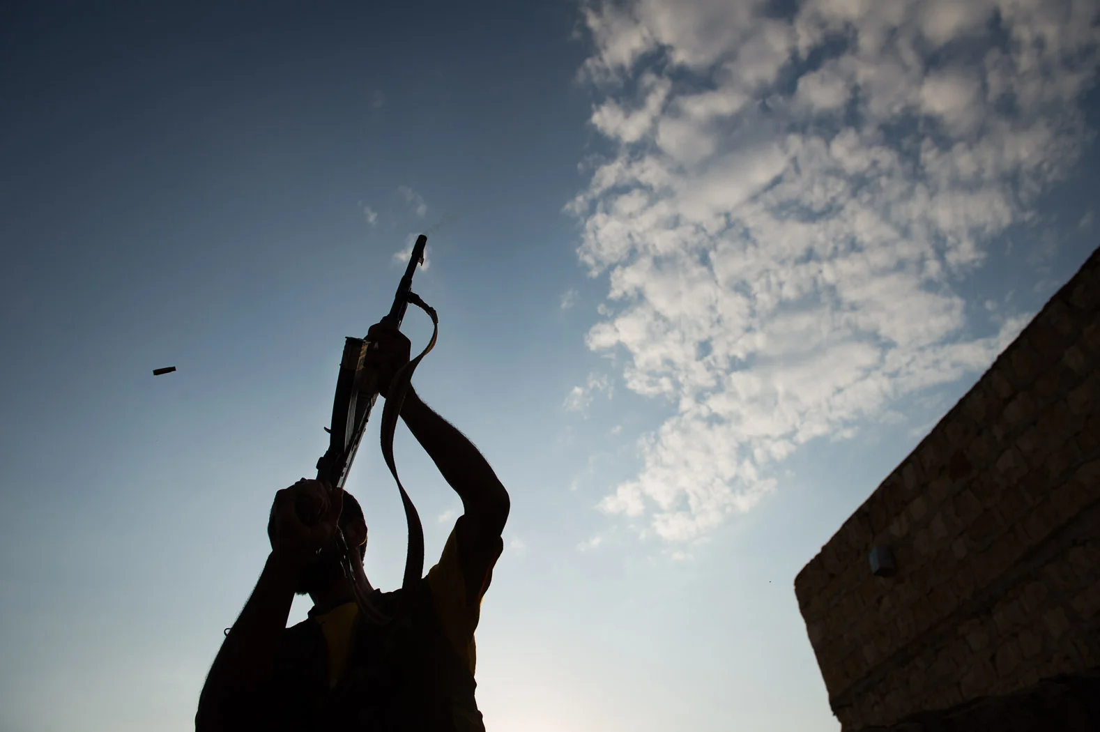 A man fires an AK-47 in rebel-held Syria