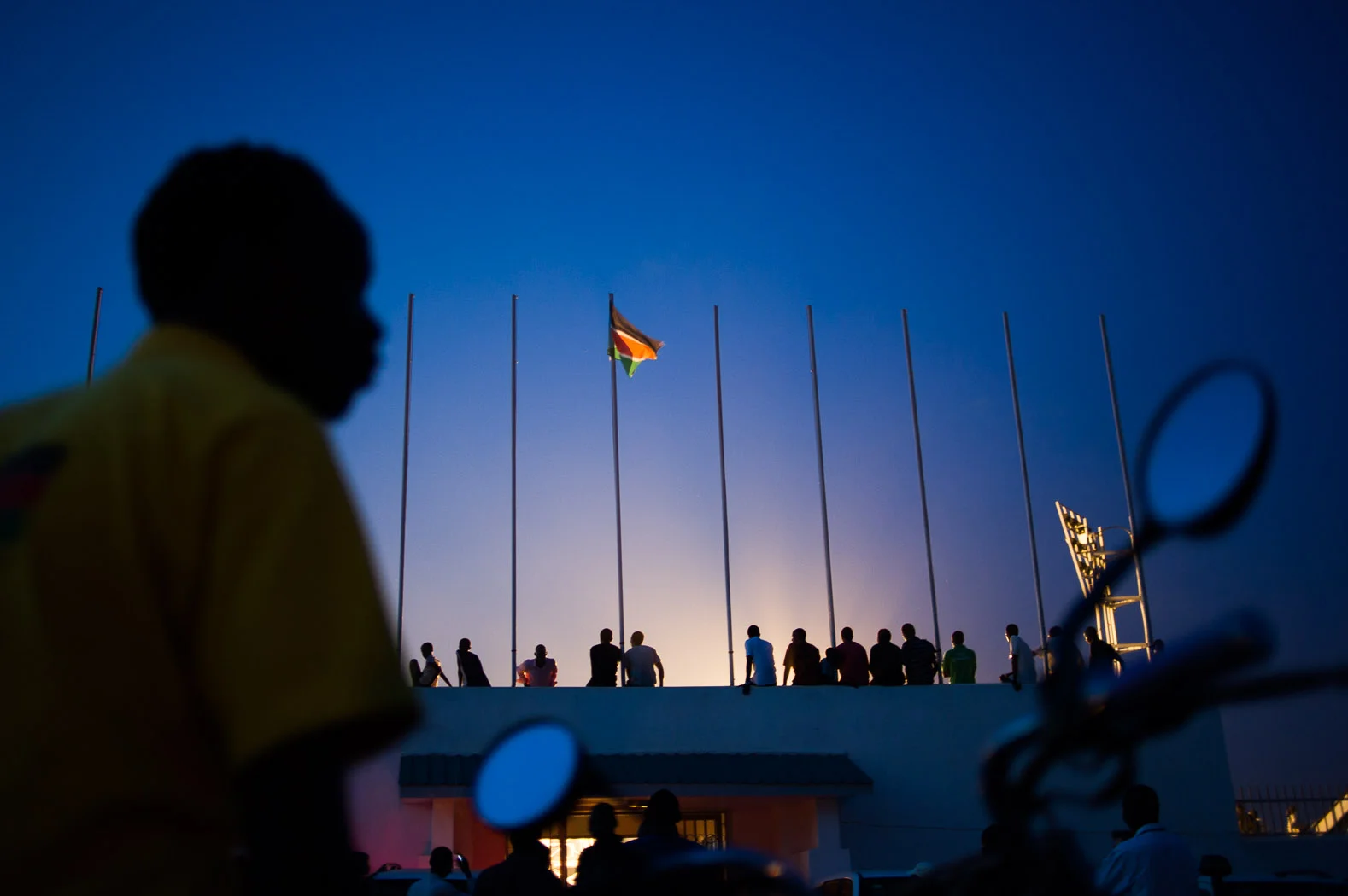 A motorcycle taxi driver waits for clients outside of Juba's basketball stadium in South Sudan, several months after the country's independence in 2011
