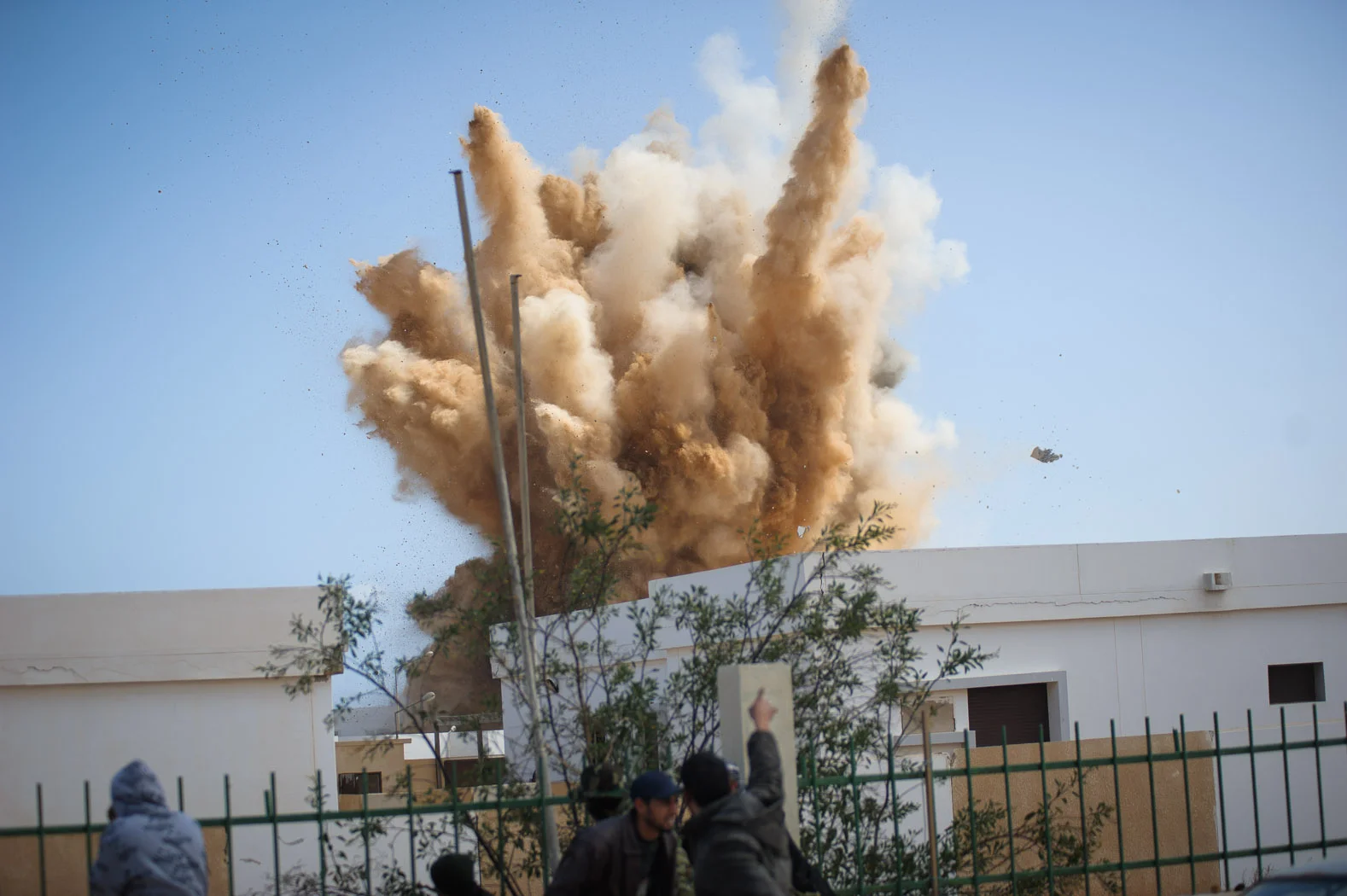 A bomb, dropped by a Libyan air force plane, explodes on a house in Ras Lanuf during the early days of the Libyan revolution