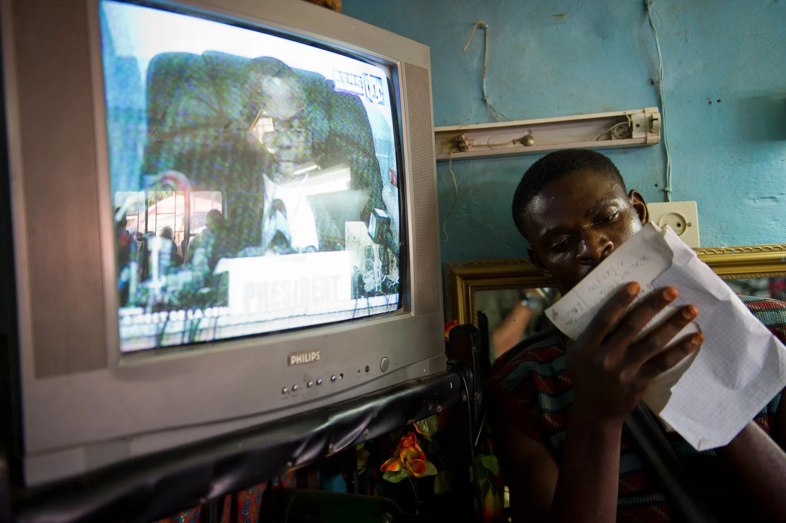 An opposition supporter notes down the results for incumbent President Jospeh Kabila and opposition candidate Etienne Tshesekedi during the live announcement of results.