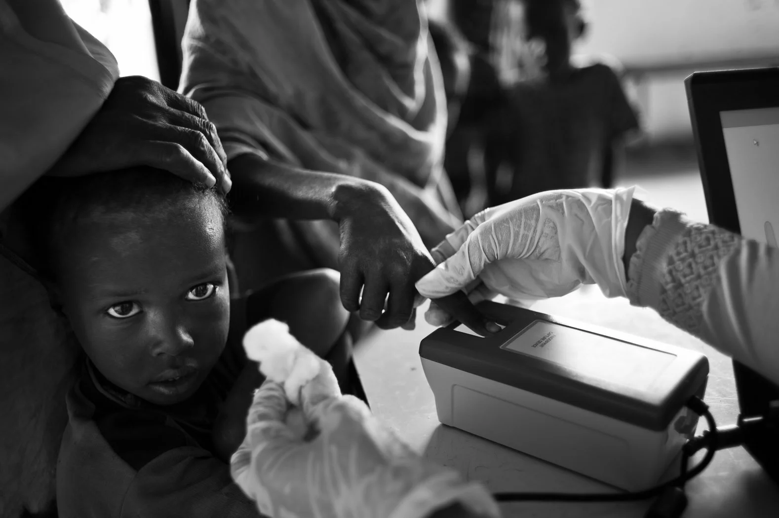 A newly arrived refugee has her fingerprint scanned as she and her family registers at a reception centre in Dagahaley camp in Kenya's Dadaab refugee complex. This is the first step in the long process of becoming a refugee in Dadaab, and screens against double-registrations.