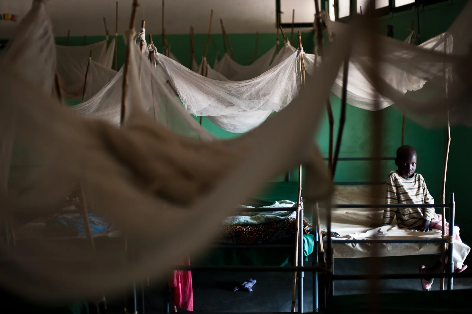 Many children have been injured in the bombings. At this health facility in the Nuba mountains -- the only hospital in the region -- a child sits on a bed covered by mosquito nets.