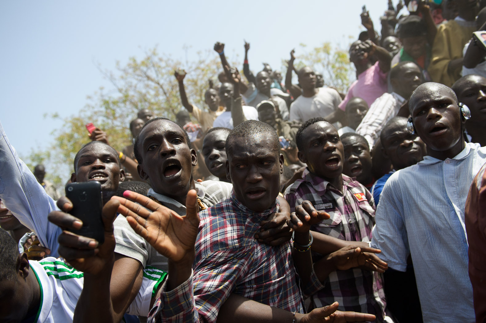 Supporters of incumbent President Wade react as police disperse them.