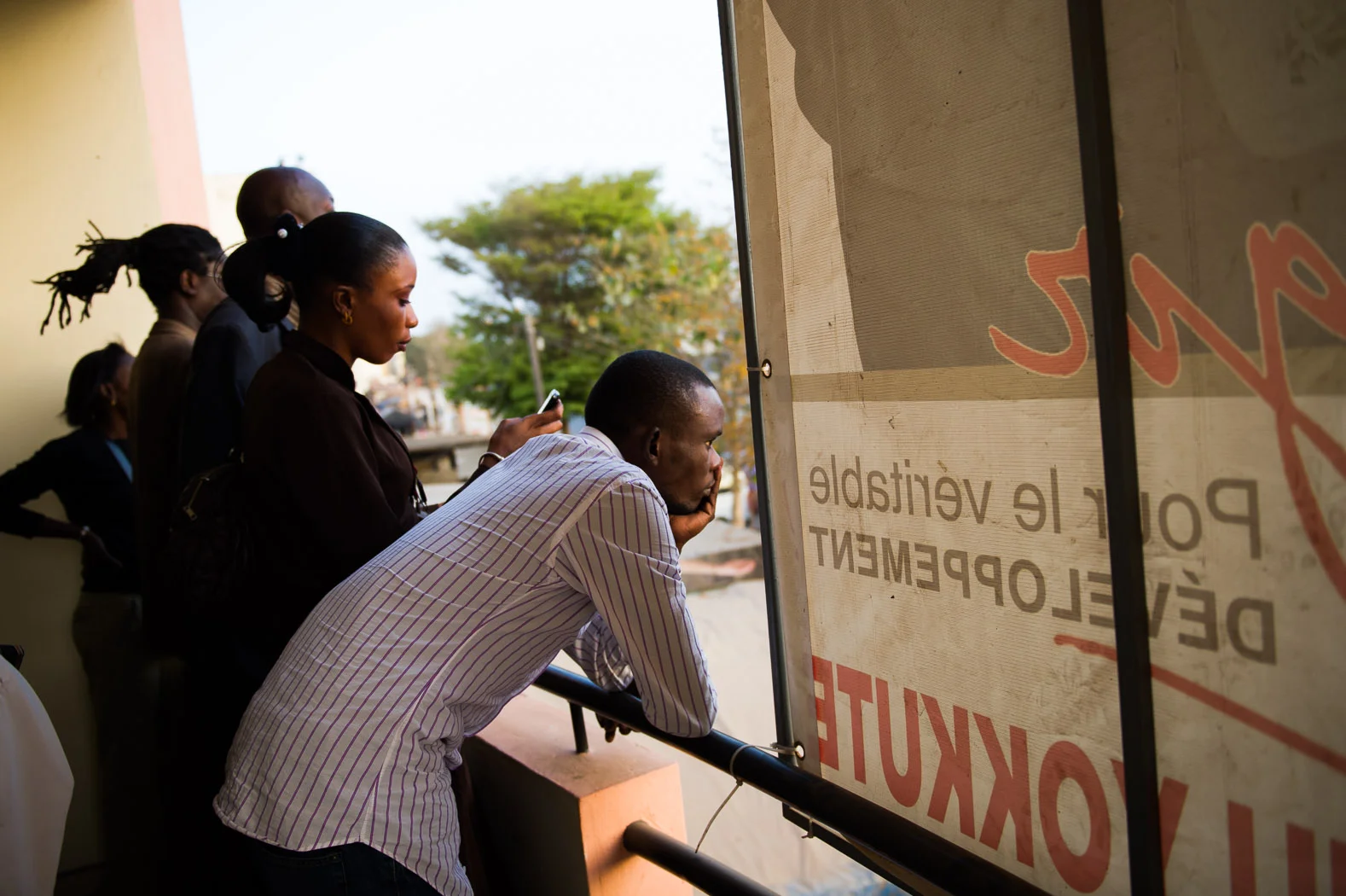 Campaign team members for Macky Sall watch as supporters gather outside the party headquarters.