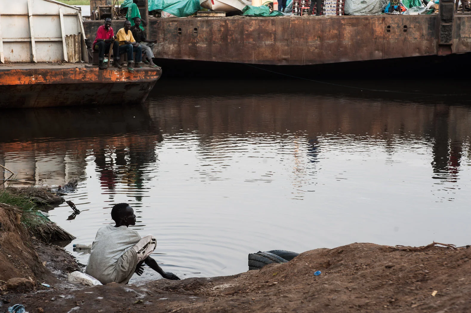 A trader from one of the many barges that plies the Nile between north and south Sudan, washes in the river at dusk. With such a poor road network -- due to infrastructure and seasonal rains -- much of the goods transported through South Sudan, particularly from Khartoum, are shipped by the river.