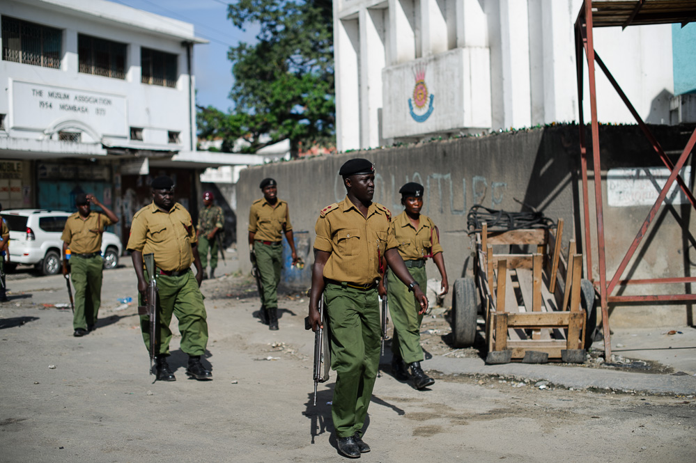 Kenyan security officers walk through the streets of the Majengo neighbourhood during rioting
