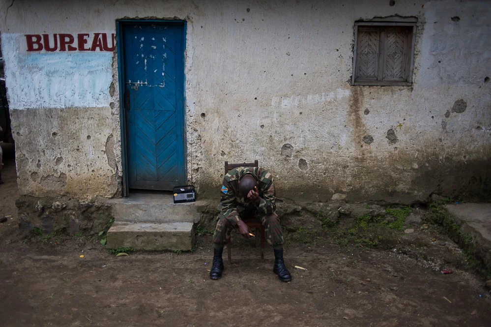An officer rests at a village between Kibumba and Rutshuru