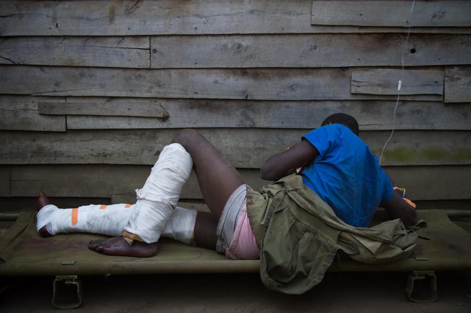 A captured M23 combatant is treated in the village of Rusayo by Congolese army troops. The man claims he was forced to fight by the rebels.