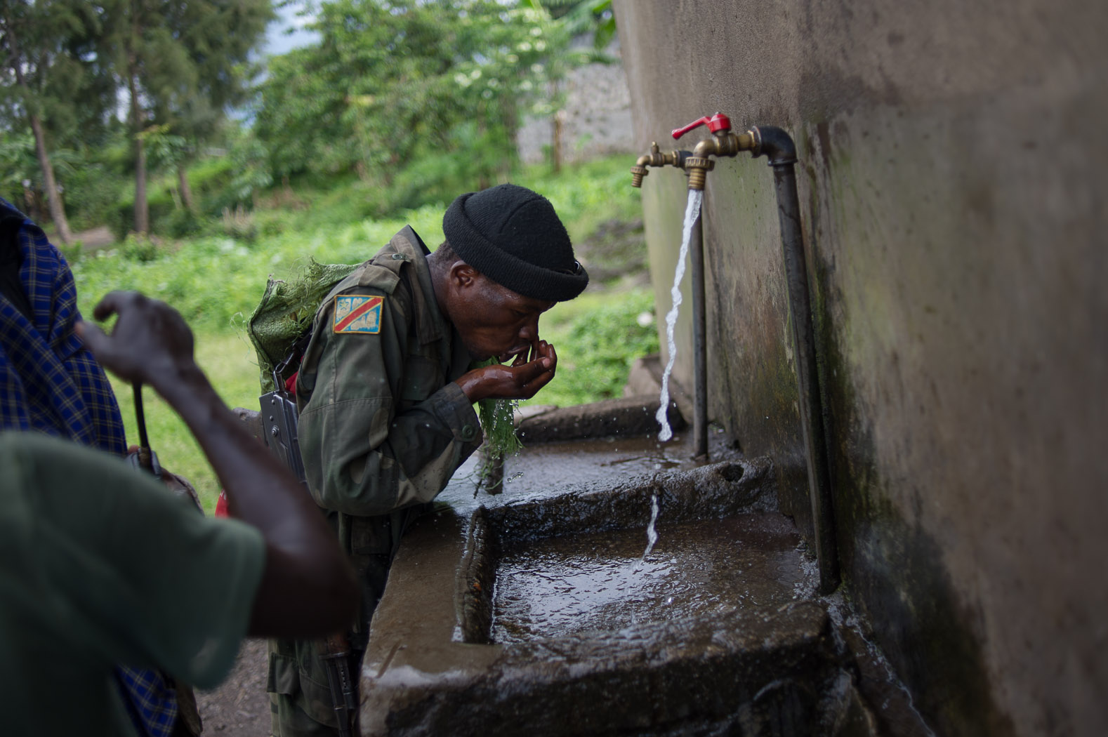 Congolese army soldiers drink water on the long walk up to Bunagana as they deploy to retake the town.
