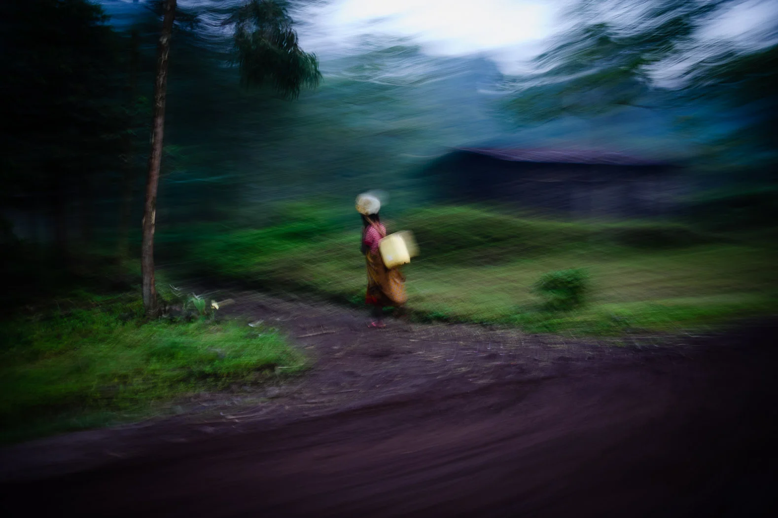 A woman carries jerry-cans of water