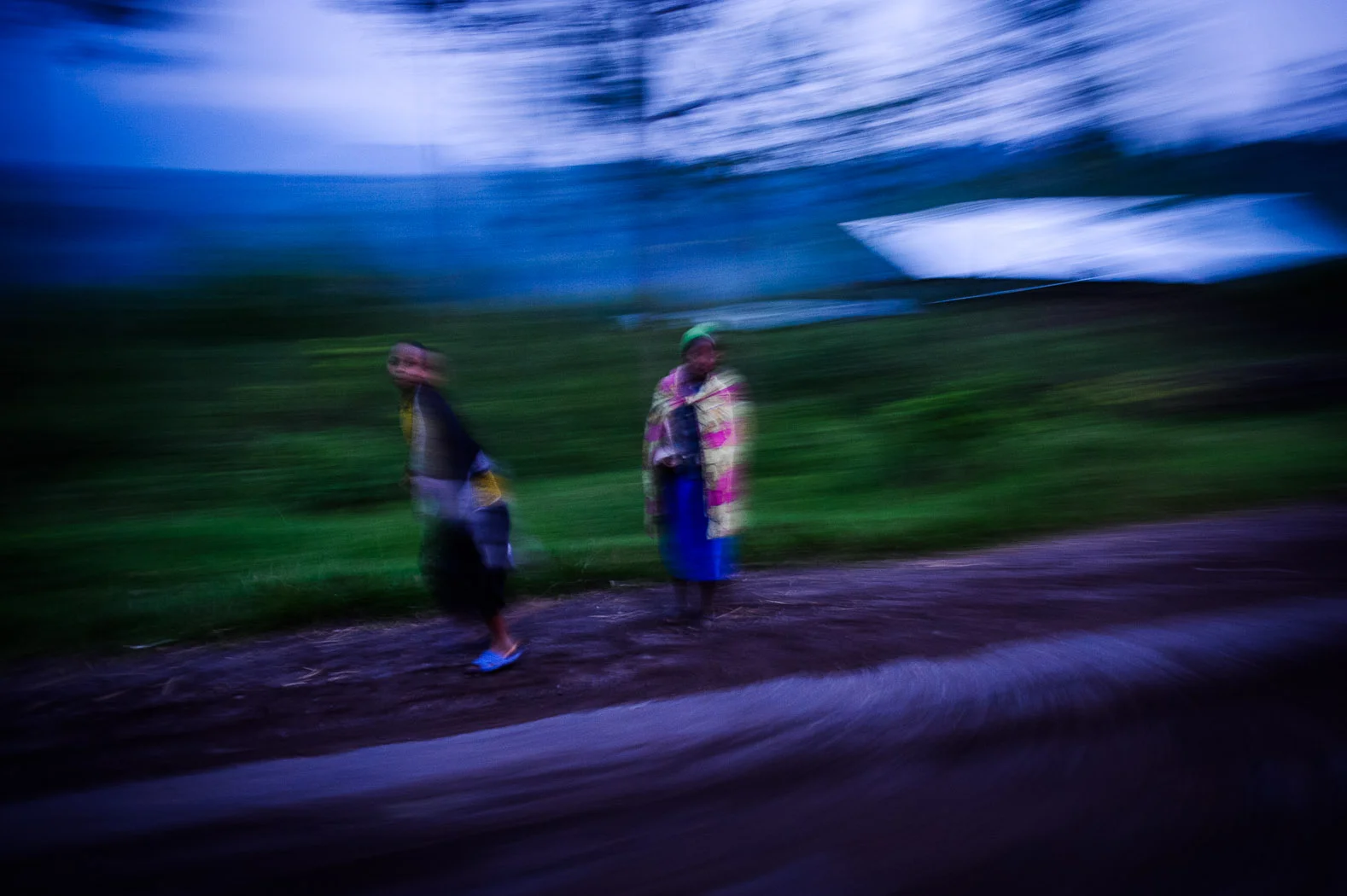 Two girls walk through Kanyarucinya