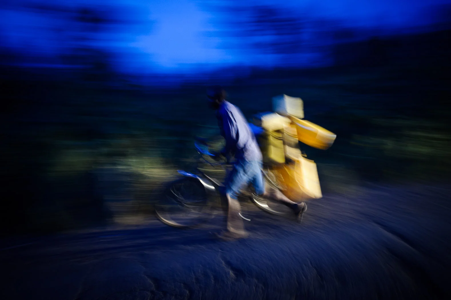 A man pushes a bicycle loaded with jerry-cans on the outskirts of Goma