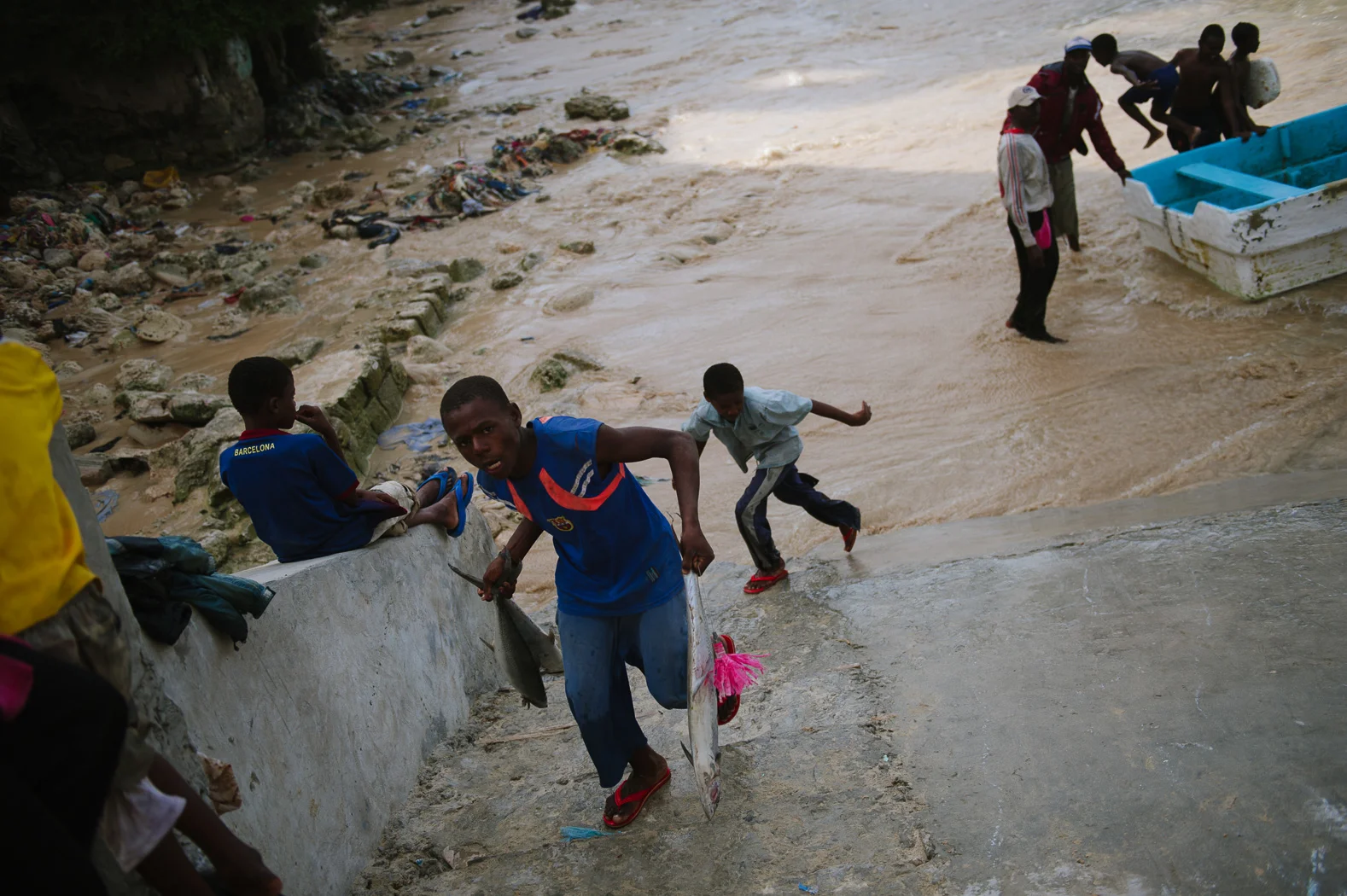 A boy runs with the fresh catch from the boat to the nearby fish market.