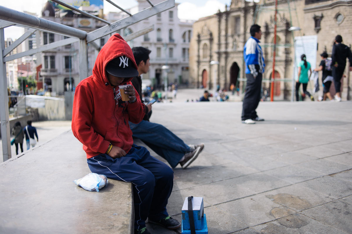 Ruben Flores (13) drinks a cup of tea given to him by a women's organisation, whilst he works as a shoe shiner on the streets of La Paz, Bolivia.