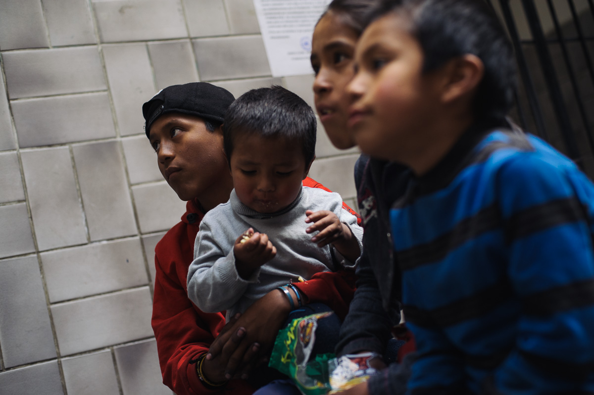 Ruben Flores (13) sits with his younger siblings as they watch television in the "New Day Foundation" centre where the family lives in La Paz, Bolivia. Ruben works as a shoe-shiner, and his income helps to provide for the family when times are tough.