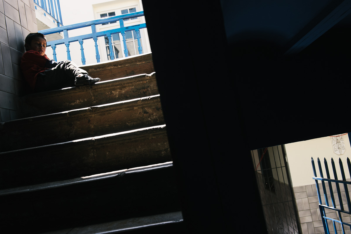 Jonny, Ruben's five year old brother, sits on a staircase in the "New Day Foundation", a centre for shoe-shiners where he lives with his family in La Paz, Bolivia.