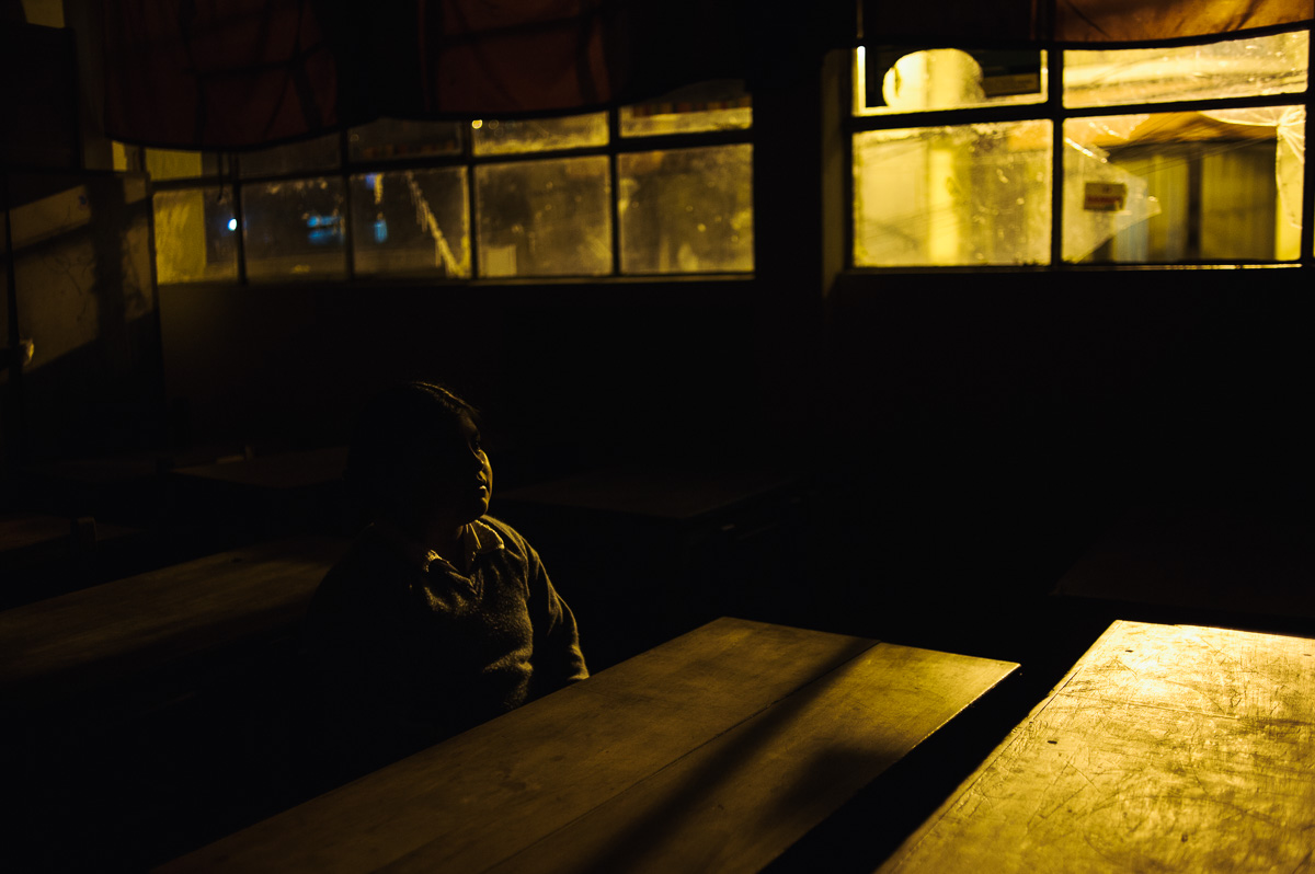 Betsabel (8) poses for a picture in her classroom after a night-school class with her father in La Paz, the Bolivian capital. Betsabel works for her godparents as domestic help, earning her keep from them, despite being two years too young to legally work under Bolivia's child labour laws.