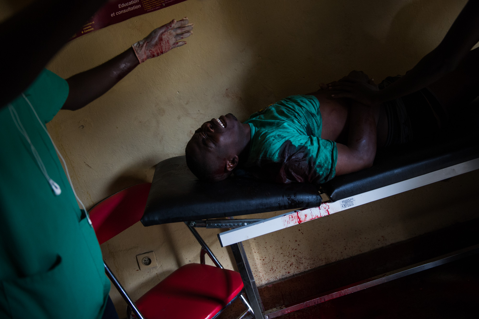 Pascal lies injured on a gurney in a small health centre following clashes with police in the Musaga neighbourhood of Bujumbura, Burundi, on May 4, 2015. He was injured by a gunshot, and later died.