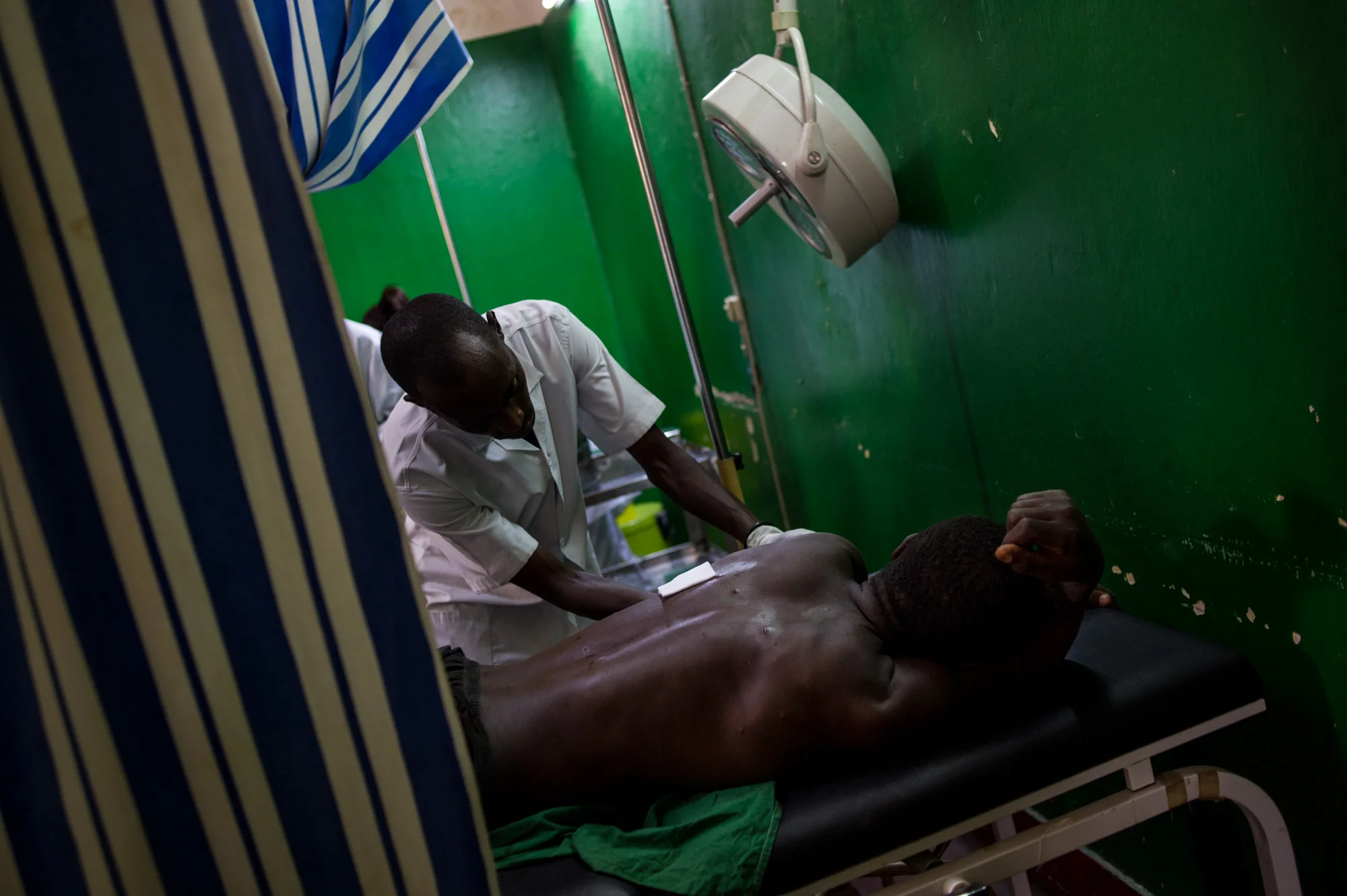A man is treated for shrapnel wounds following a blast in down-town Bujumbura, one of several that day.