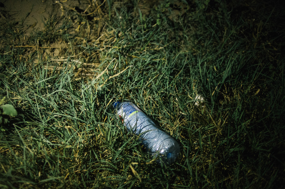A water bottle is left by the side of a track in the fields between the Serbian and Croatian border, pictured during the night of September 17, 2015, near Tovarnik, Croatia.