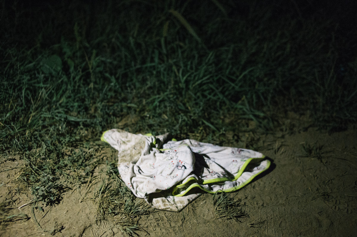 A baby's bib is left by the side of a track in the fields between the Serbian and Croatian border, pictured during the night of September 17, 2015, near Tovarnik, Croatia.