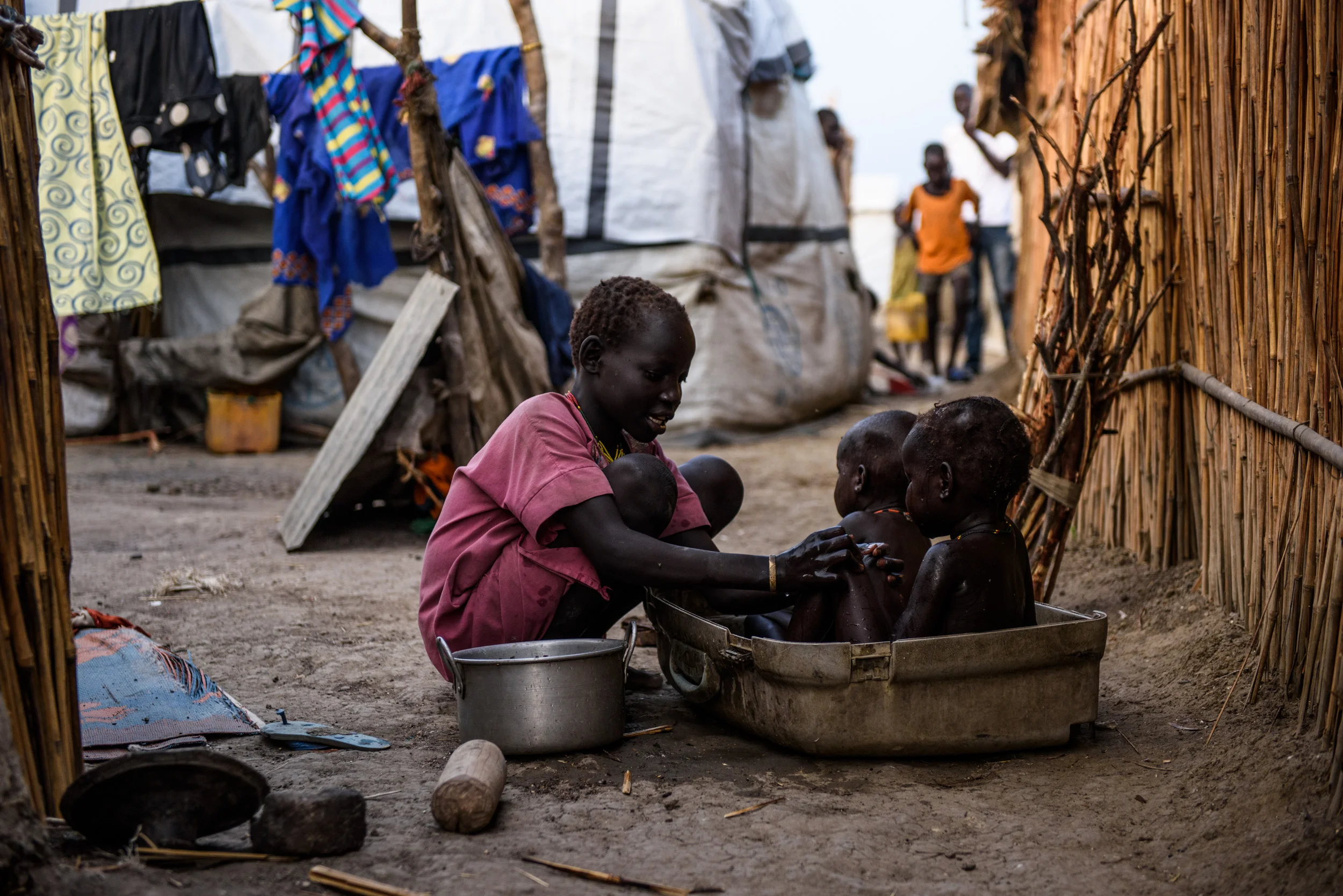 A young girl washes her siblings in part of an old, damaged suitcase in the Protection of Civilians (PoC) site in Bentiu, South Sudan, on May 1, 2017.
Photo by Phil Hatcher-Moore - UNICEF