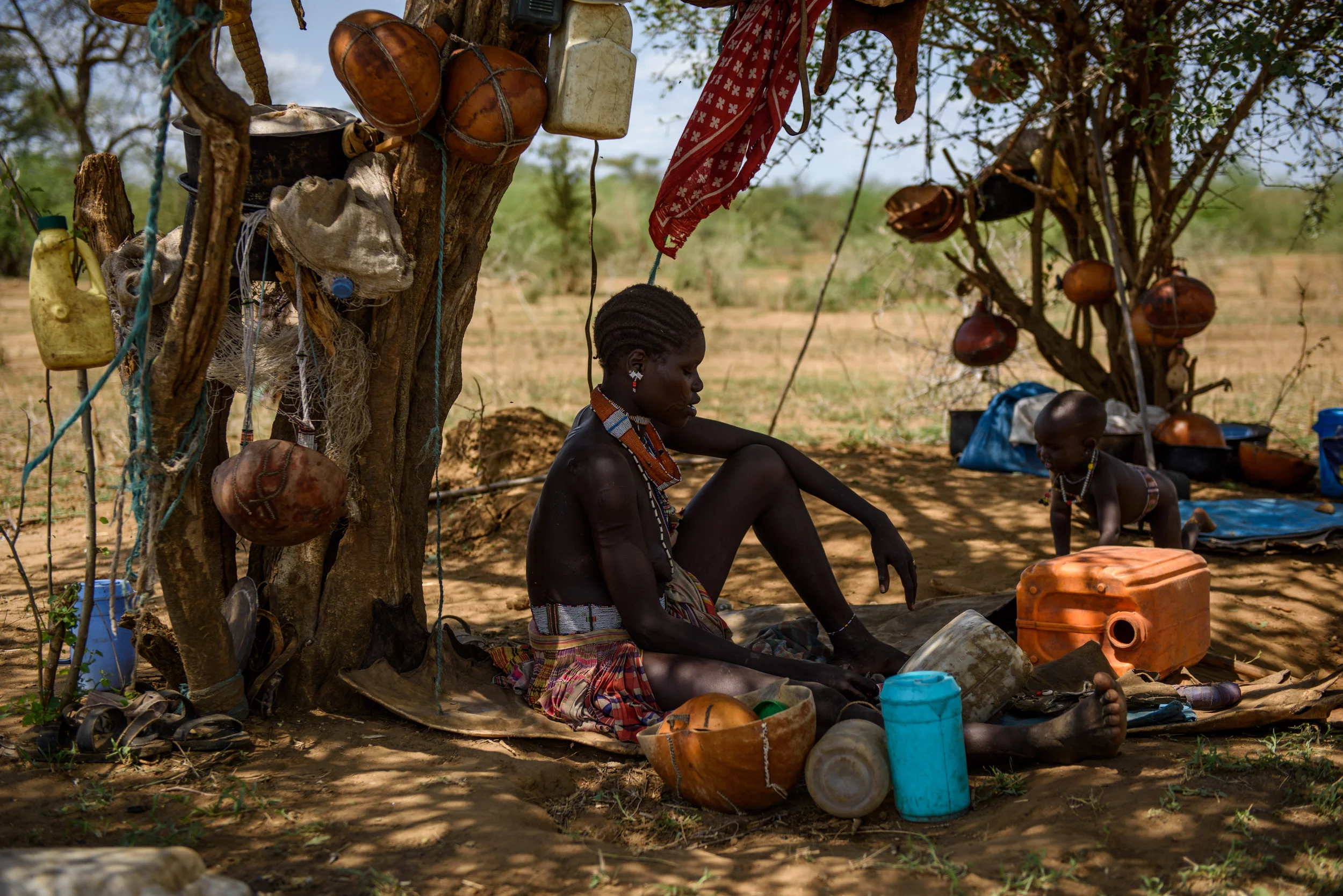 A mother and children from the Toposa tribe sit under a tree at a cattle camp in Lotelet, Kapoeta North, in South Sudan, on May 24, 2017. Whilst fighting has largely avoided the area, the conflict compounds an already poor area, which is in the midst of a drought, and the region is in the midst of a cholera outbreak.