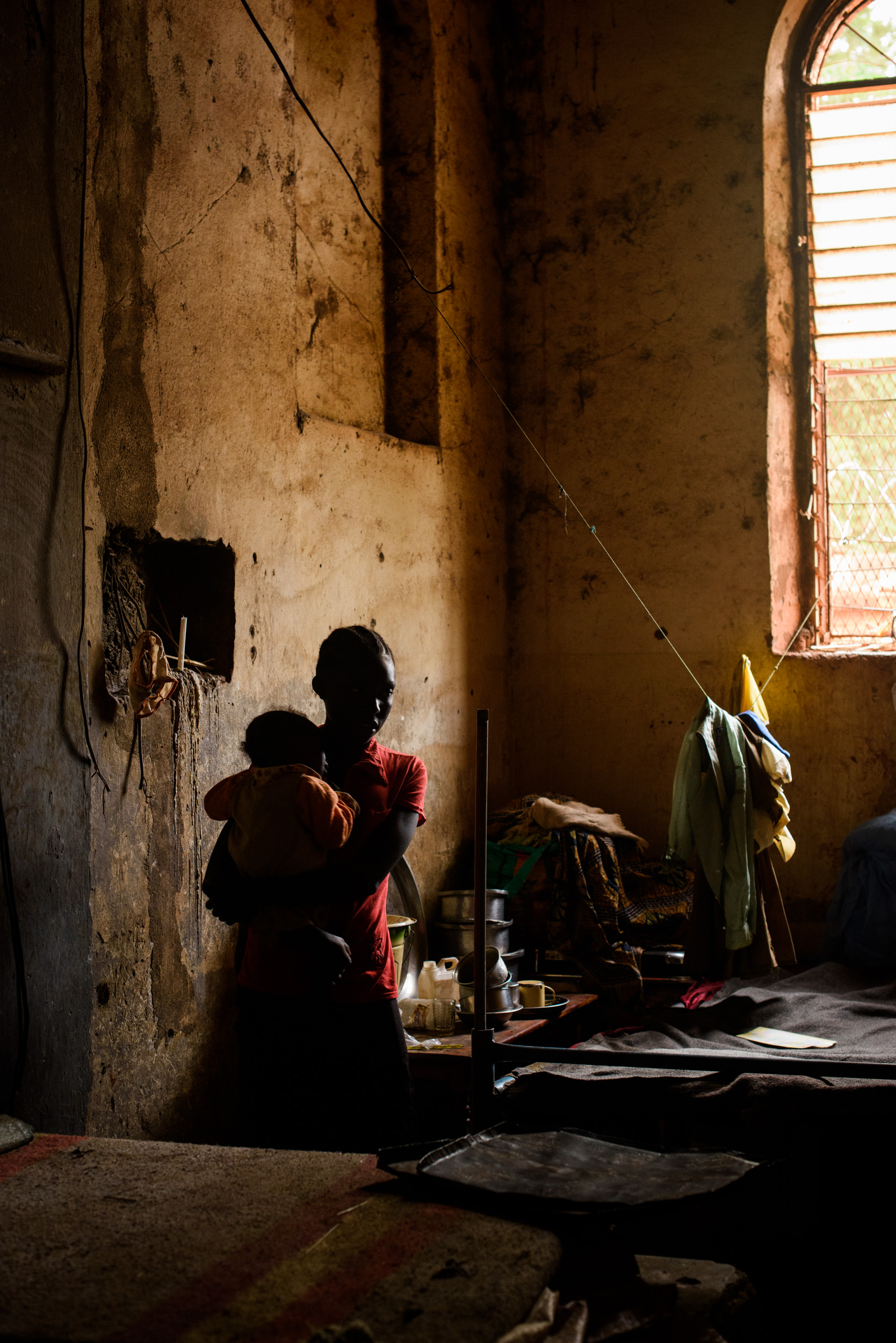 Estelle Charles (15) stands with her six month old sister in an old church hall where she and her family live in an informal camp for the displaced in St. Mary's cathedral in Wau, South Sudan, on June 15, 2017. The hall was the original church, before the cathedral was built in the 1950s. Around 13,000 live in the cathedral grounds, having sought refuge from the fighting that broke out here a year ago.
Photo by Phil Hatcher-Moore - UNICEF