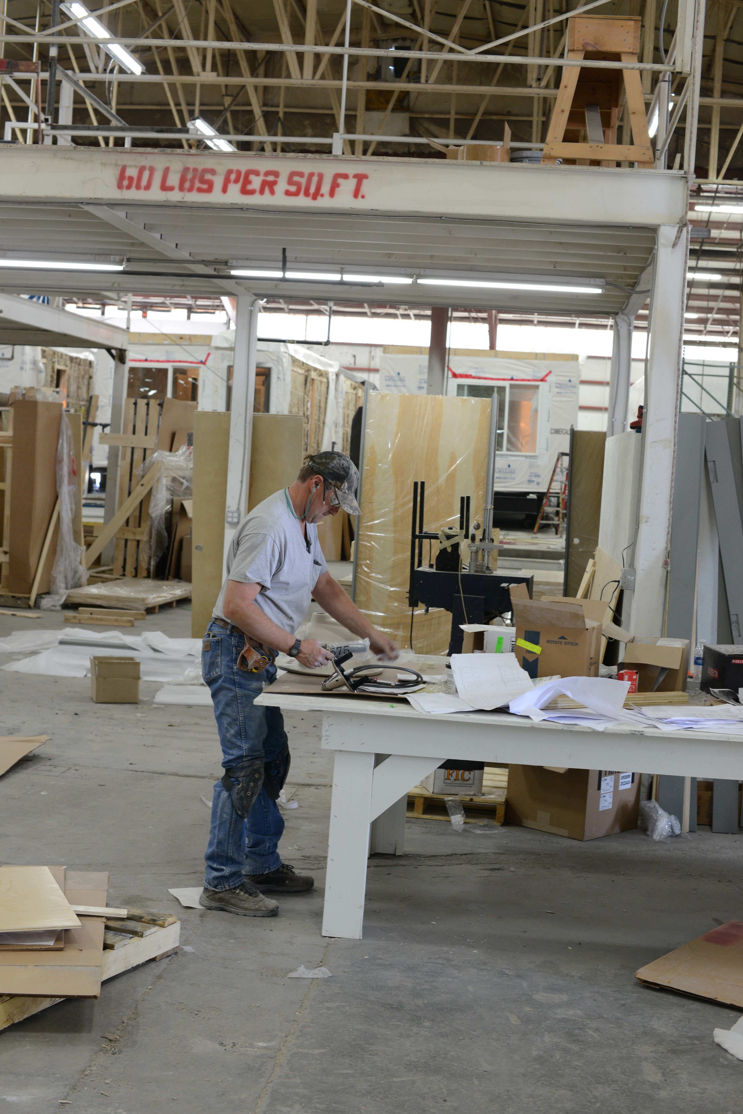 Key finish carpentry elements and plumbing assembly is done off line in stations. Here a plumber assembles plumbing fixtures to their countertops offline.