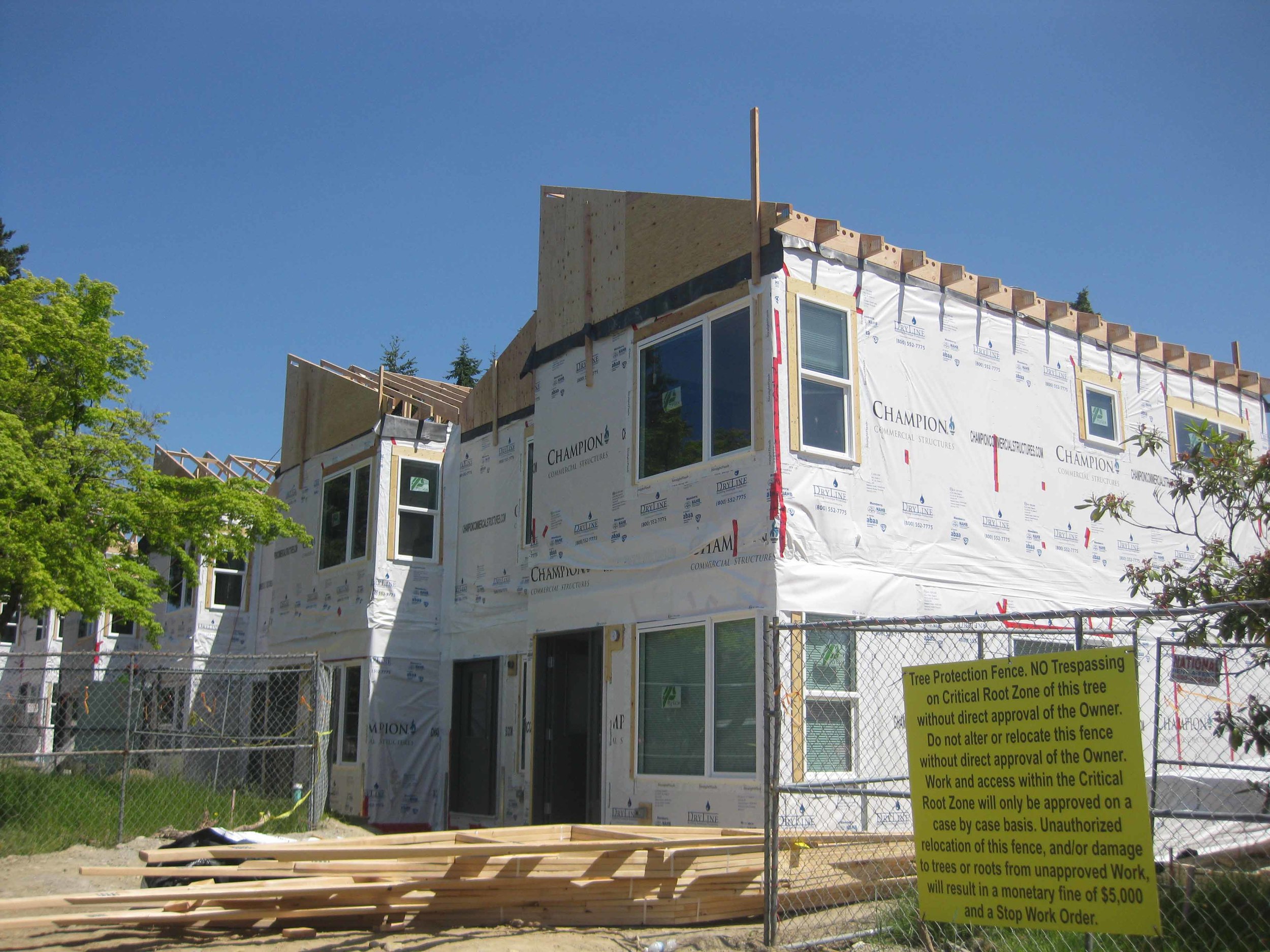 Once the boxes have been set, the construction takes on a more typical construction process. The air barrier is seamed together at all gaps between modules, all while the roof trusses are set atop the second floor modules. Once the trusses are in place, the roof is sheathed, papered, and shingled.