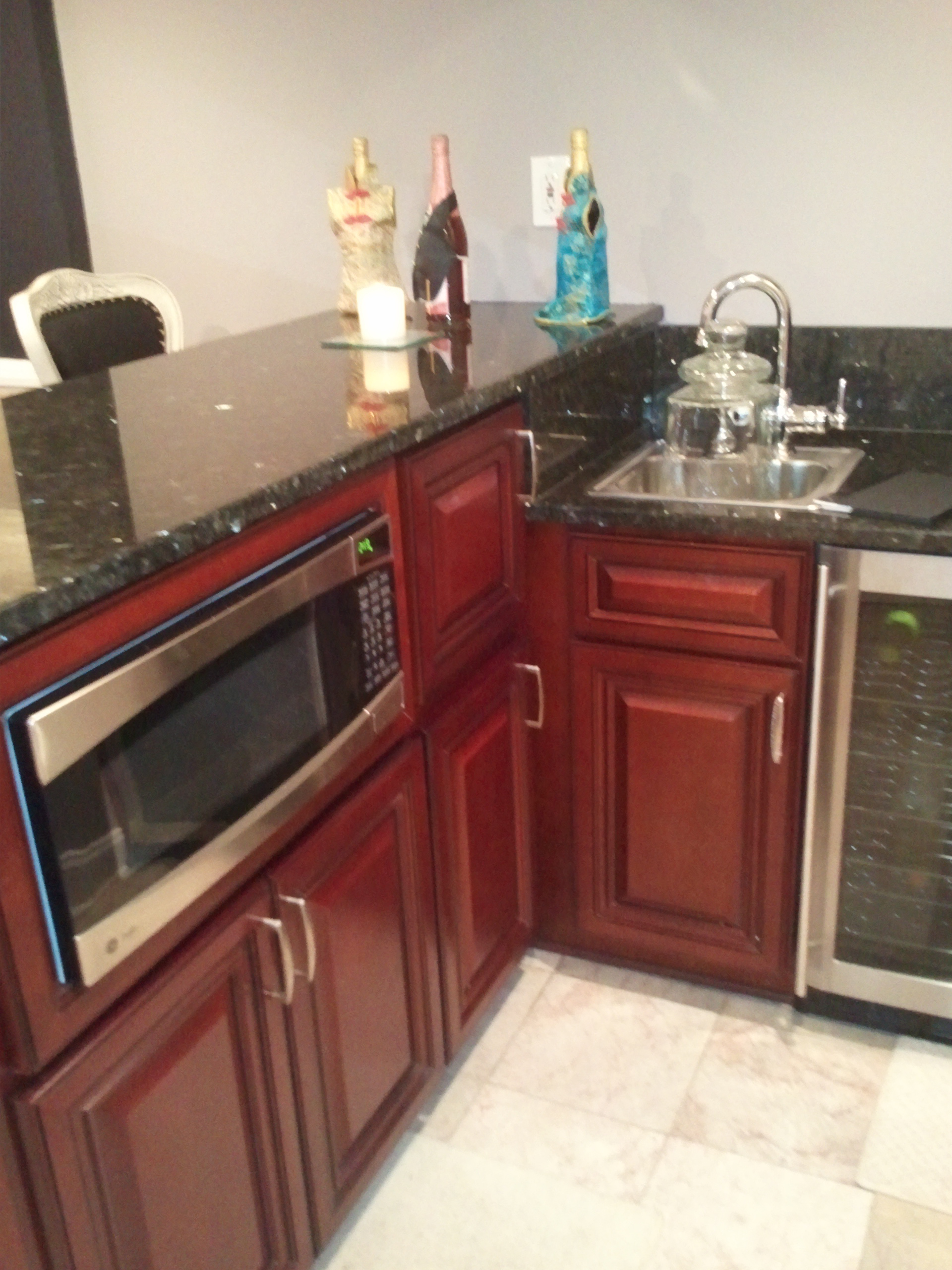 A bar custom built to include a microwave, a sink and a fridge.