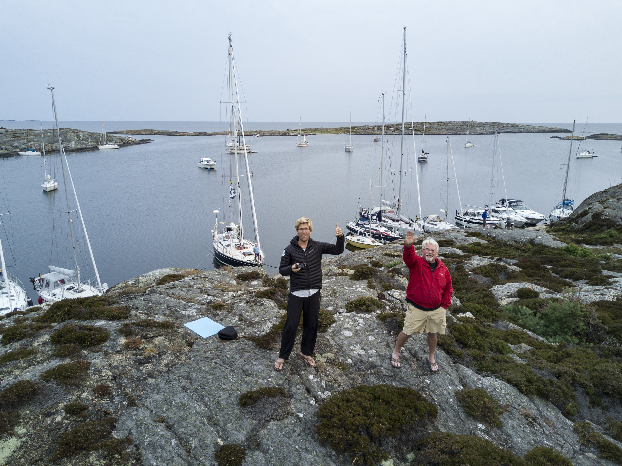 Andy & his dad Dennis flying the drone in Mollön Isbjorn in the background anchored to the cliffs.